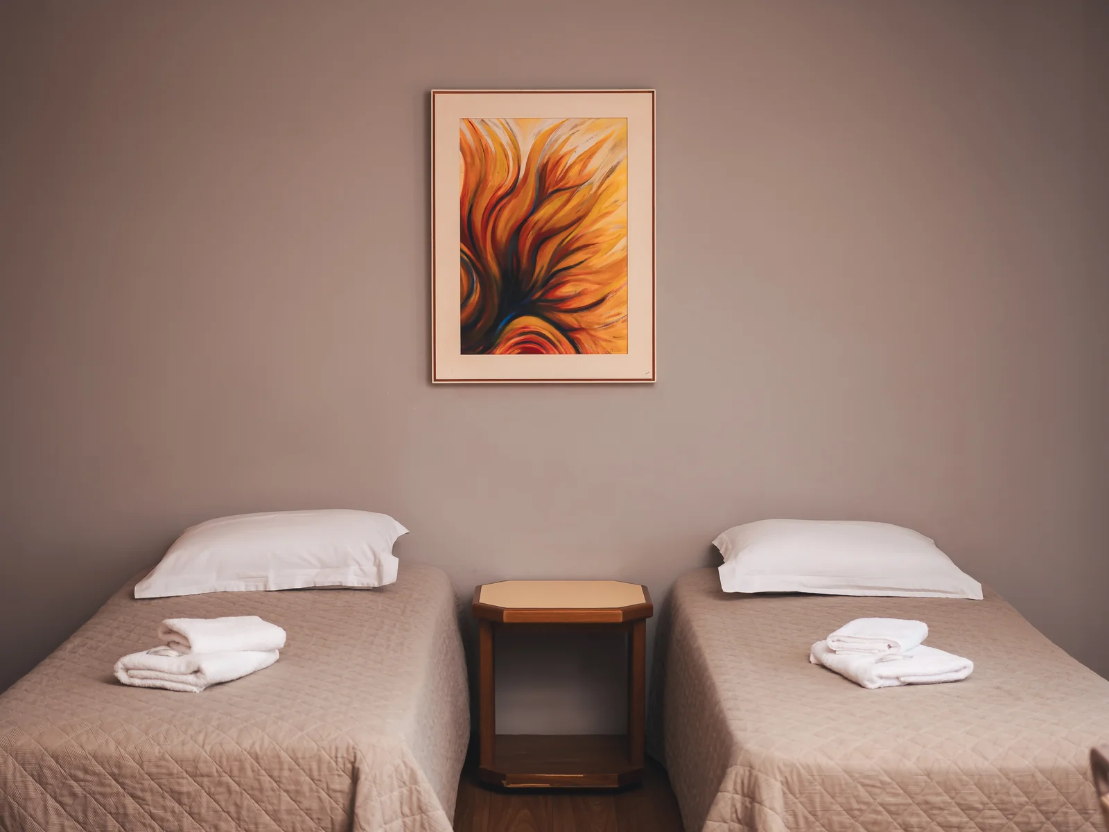 Duas camas de solteiro com criado-mudo e quadro na Suíte Família do Sítio Hotel & Eventos